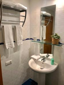 bagno con lavandino, specchio e asciugamani di El Rincón de las Armas a Saragozza