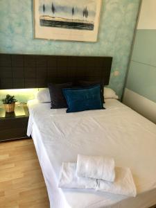 una camera da letto con un grande letto bianco con due asciugamani di El Rincón de las Armas a Saragozza