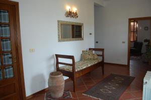 a living room with a chair and a mirror at Agriturismo La Sede Di Carlo in Saturnia