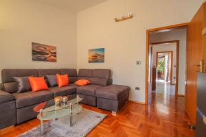 een woonkamer met een bruine bank en een tafel bij Apartment Nada in Pula