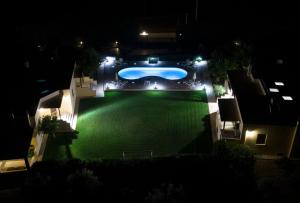 an aerial view of a yard at night with a swimming pool at Naxos Cottage in Káto Sangríon