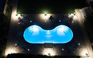 a blue swimming pool with chairs and lights at Naxos Cottage in Káto Sangríon