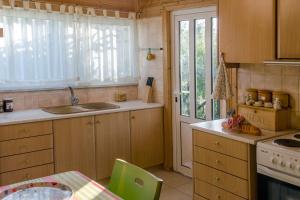 a kitchen with wooden cabinets and a sink and a table at Casa di Diamanto in Porto Rafti