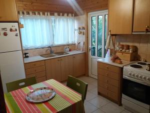 a small kitchen with a table with a table cloth on it at Casa di Diamanto in Porto Rafti +24 photos