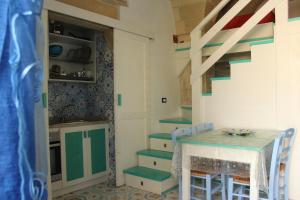 オートラントにあるOtranto Vacanza Facile - La Corteのキッチン(テーブル、椅子、階段付)
