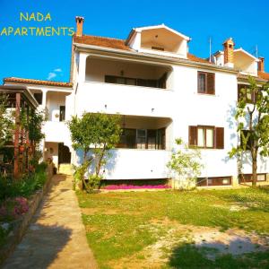 a white house with a yard in front of it at Filipo Apartments in Poreč