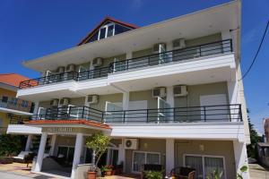 a large white building with balconies on it at Iraklis Hotel in Mytikas