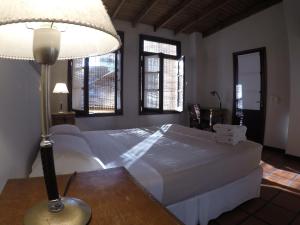 a bedroom with a bed and a lamp on a table at Posada Gotan in Buenos Aires