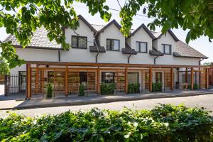 ein Haus mit hölzernen Fensterläden an der Fassade in der Unterkunft Villa Madre Golf & Family in Wisełka