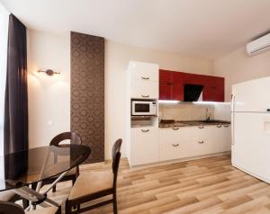 a kitchen with a glass table and a kitchen with red cabinets at Shestaya Zhemchuzhina in Odesa