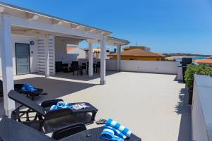 un patio avec des chaises et une table sur le toit dans l'établissement MareinSicilia: Talia Residence, à Sampieri