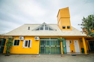 uma casa amarela com um portão em frente em Pousada Nona Amabile em São Lourenço do Sul