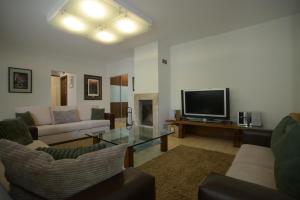 a living room with a couch and a television at Apartmán Lomnica in Tatranská Lomnica