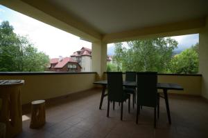 einen Balkon mit einem Tisch und Stühlen sowie einem großen Fenster in der Unterkunft Apartmán Lomnica in Tatranská Lomnica