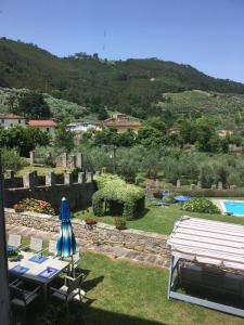 vistas a un jardín con mesas y sombrillas en Villa Ilaria, en Capannori