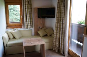 a living room with a couch and a window at Pension Hohe Salve in Westendorf
