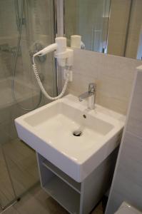 a white sink in a bathroom with a shower at Pension Hohe Salve in Westendorf