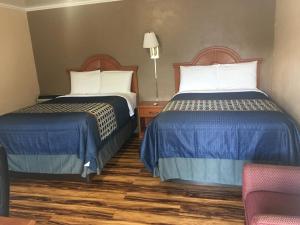 A bed or beds in a room at Hilltop Inn