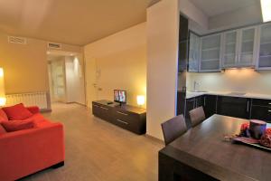 a living room with a red couch and a kitchen at Lagaya Apartaments & Spa in Valderrobres