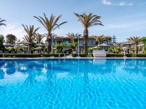 a large swimming pool in front of a resort at Marinos Beach Hotel in Platanes