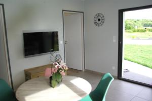 a dining room with a table and a tv at Gîte entre mer et montagne in Laa-Mondrans