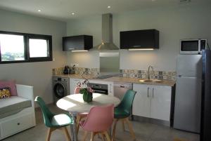 a kitchen with a table and chairs in a kitchen at Gîte entre mer et montagne in Laa-Mondrans