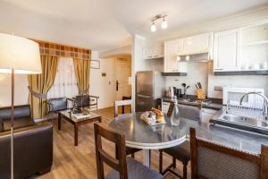 a kitchen with a table, chairs and a refrigerator at Park Plaza Apartments in Santiago