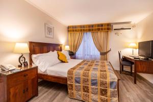 a bedroom with a bed and a desk with a telephone at Park Plaza Apartments in Santiago +26 photos