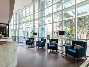 - un hall avec des chaises, des tables et de grandes fenêtres dans l'établissement You Stay at Vila Olimpia - ITC, à São Paulo