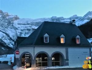 a building with windows and a snow covered mountain at La P'tite Marmotte in Gavarnie