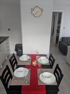 a dining room table with plates and wine glasses at LT Grove Apartment - Stratford in London