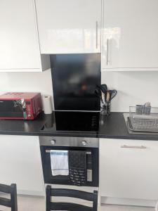 a kitchen counter with a microwave and a toaster oven at LT Grove Apartment - Stratford in London