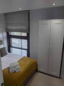 una camera da letto con un letto e due asciugamani di LT Grove Apartment - Stratford a Londra