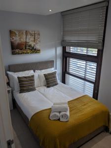 a bedroom with a bed with two towels on it at LT Grove Apartment - Stratford in London