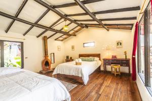 a bedroom with two beds and a wooden floor at Botanico Hostel in Bogotá