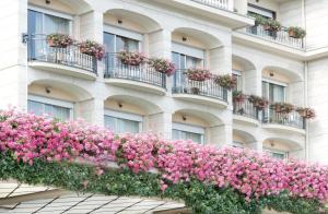 un edificio con fiori rosa sul lato di Grand Hotel Bristol a Stresa