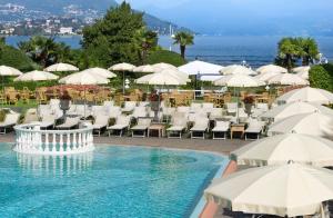 a beach area with umbrellas and chairs at Grand Hotel Bristol in Stresa