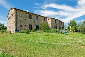 an old stone building with a bench in a field at Agriturismo Fattoria di Statiano in Pomarance