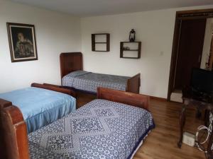 a room with two beds and a tv in it at Casa Campestre La Quinfalia in Luna Park