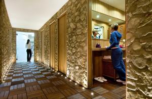 a hallway with a woman standing in a bathroom at Hotel Splendid in Baveno