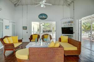 a living room with wicker chairs and a table at Hotel Agua Azul Beach Resort in Baru