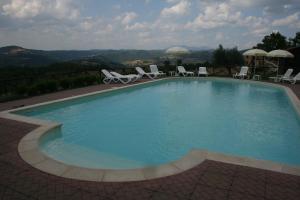 a swimming pool with chairs and a view of the mountains at Agriturismo Colle del Sole in San Martino in Colle