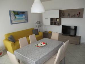 uma sala de estar com uma mesa e um sofá amarelo em SoleMare sud sardegna em SantʼAnna Arresi