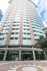 a tall building with a palm tree in front of it at You Stay at Vila Olimpia - ITC in Sao Paulo