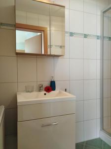 ein weißes Badezimmer mit einem Waschbecken und einem Spiegel in der Unterkunft Landhaus Sarah in Dorfgastein