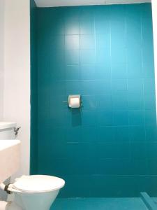 a bathroom with a toilet and a blue wall at haus_22 in Bukit Mertajam