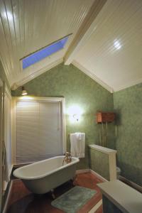 baño con bañera, ventana y lavamanos en McCloud Hotel en McCloud