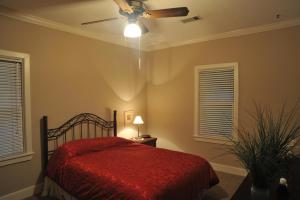 um quarto com uma cama vermelha e uma ventoinha de tecto em McCloud Hotel em McCloud