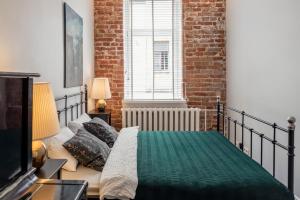 a bedroom with a bed and a brick wall at Maironis Apartment in Kaunas