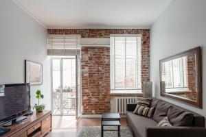 Maironis Apartment في كاوناس: غرفة معيشة مع أريكة وجدار من الطوب